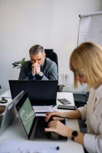 Male leader visibly stressed during a high-pressure business meeting, illustrating leadership under pressure